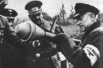 Old Man being instructed about the use of the Panzerfaust (Anti-Tank Weapon)